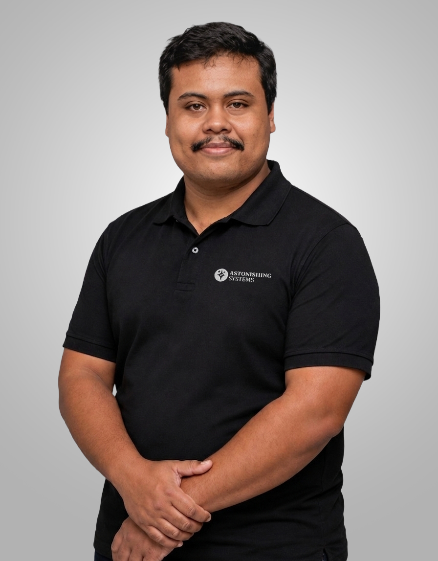 Portrait of a man with short black hair and a mustache wearing a black polo shirt with the Astonishing Systems logo.
